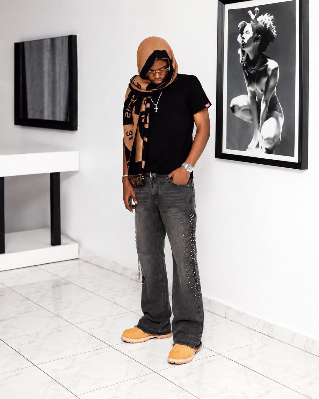 Man wearing gray baggy jeans with side studs, chains, black t-shirt and boots.