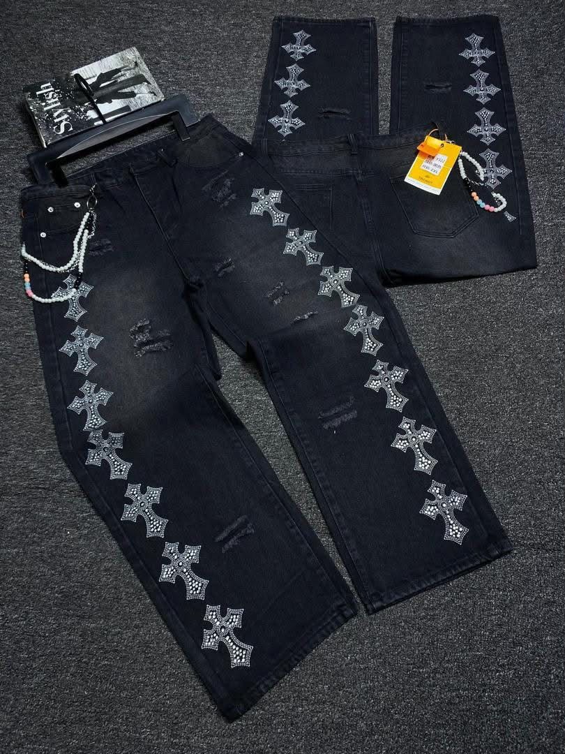 Flat lay of black baggy jeans with silver rhinestone crosses and accessories.