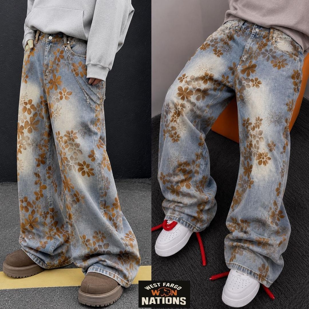Model wearing light blue baggy jeans with brown floral prints and attached silver chain.