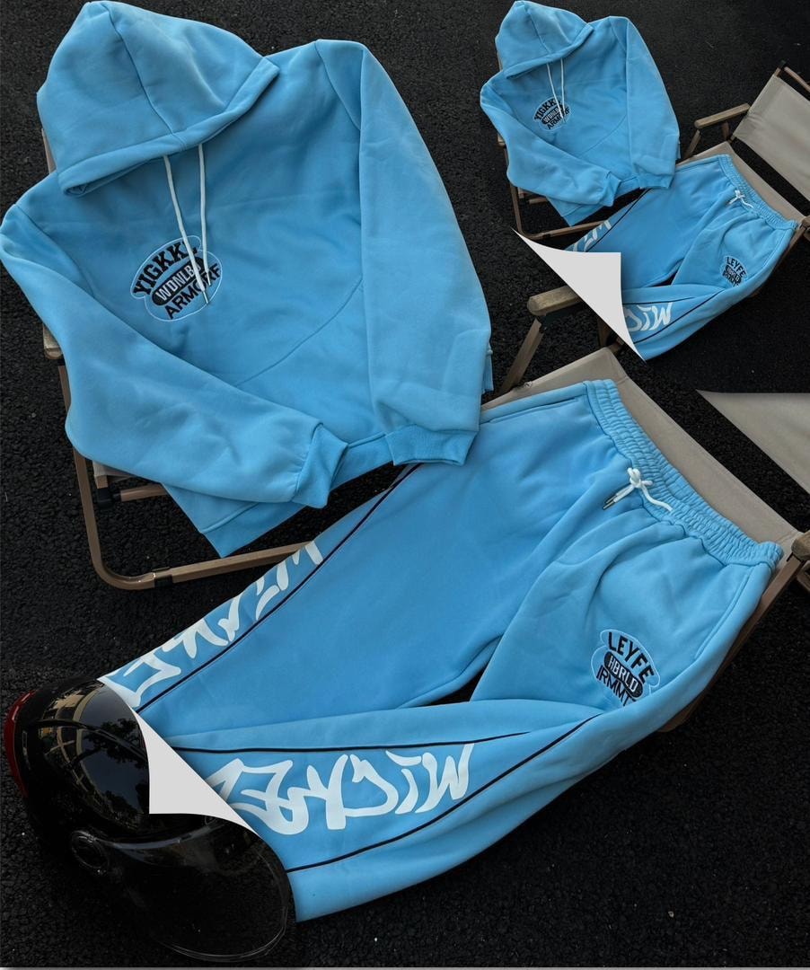 Light blue hooded two-piece set with white graphic prints arranged on chairs.