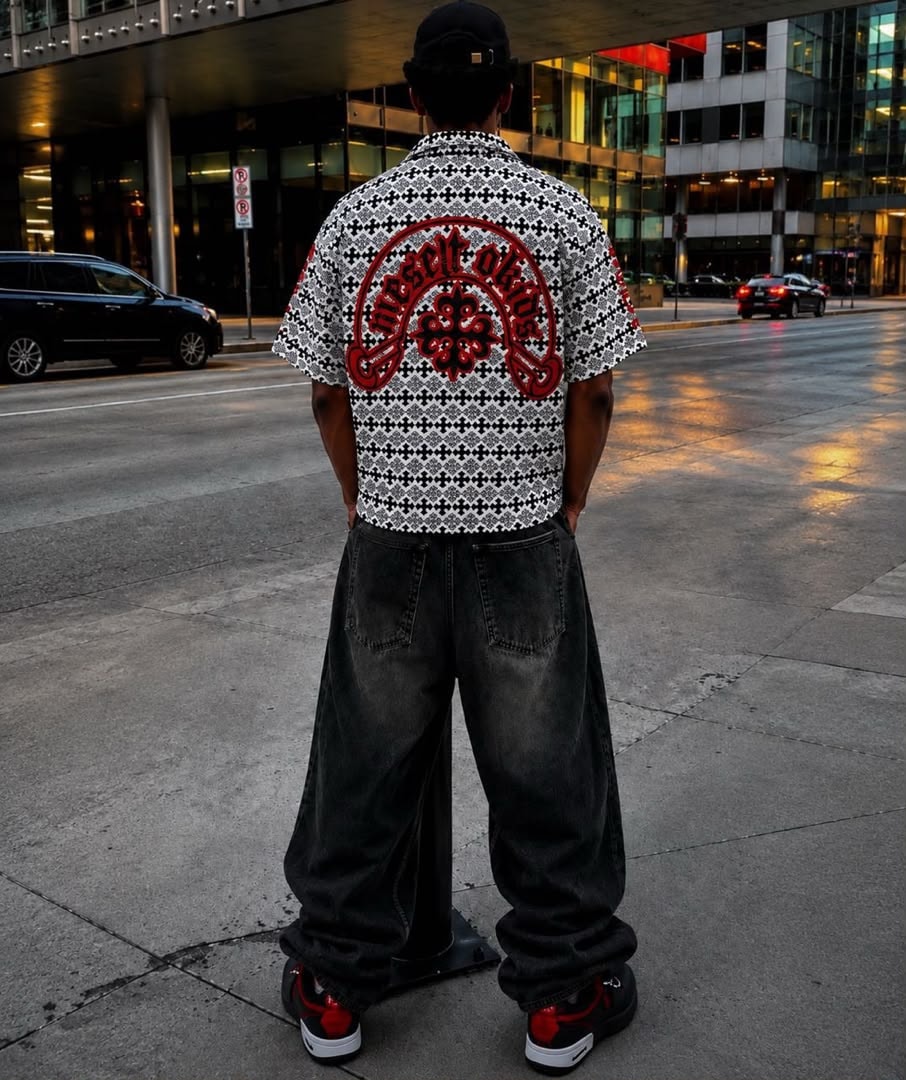 Man in black and white cross pattern polo viewed from back showing large red graphic.