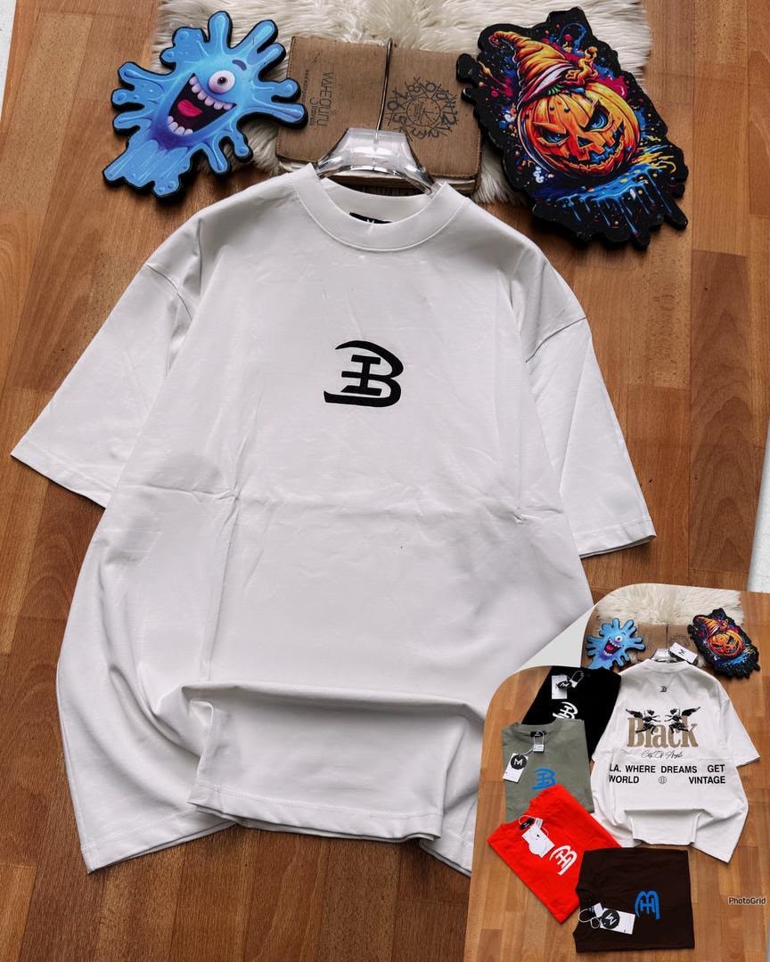 White oversized t-shirt with black B logo on chest laid on wooden floor with accessories.