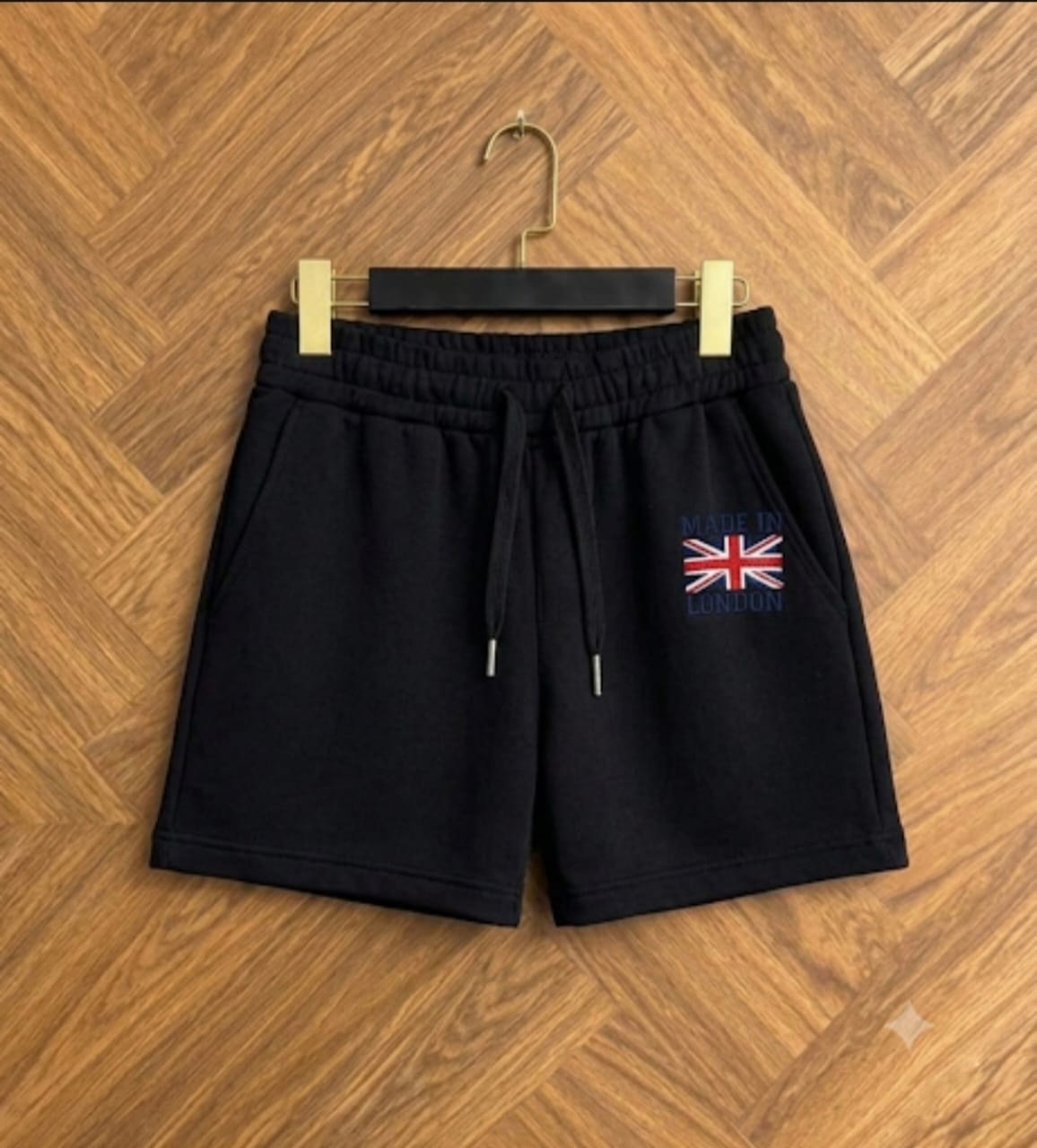 Black fleece shorts with drawstring and Made in London embroidery displayed on hanger.