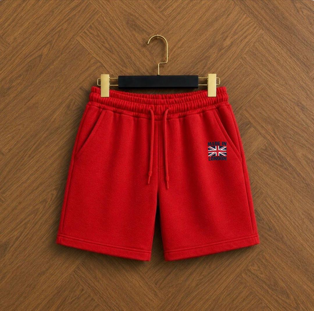 Red fleece shorts with elastic waistband, drawstring, and embroidered Made in London graphic.