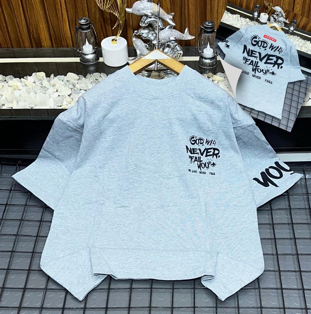 Light blue oversized t-shirt with God Will Never Fail You text print on chest, sleeve and back inset.