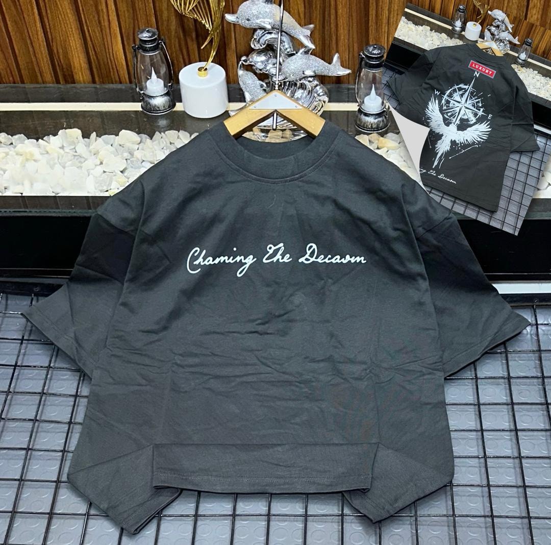 Dark gray oversized t-shirt with white cursive 'Chaming The Decaom' print on front and inset bird compass back view.