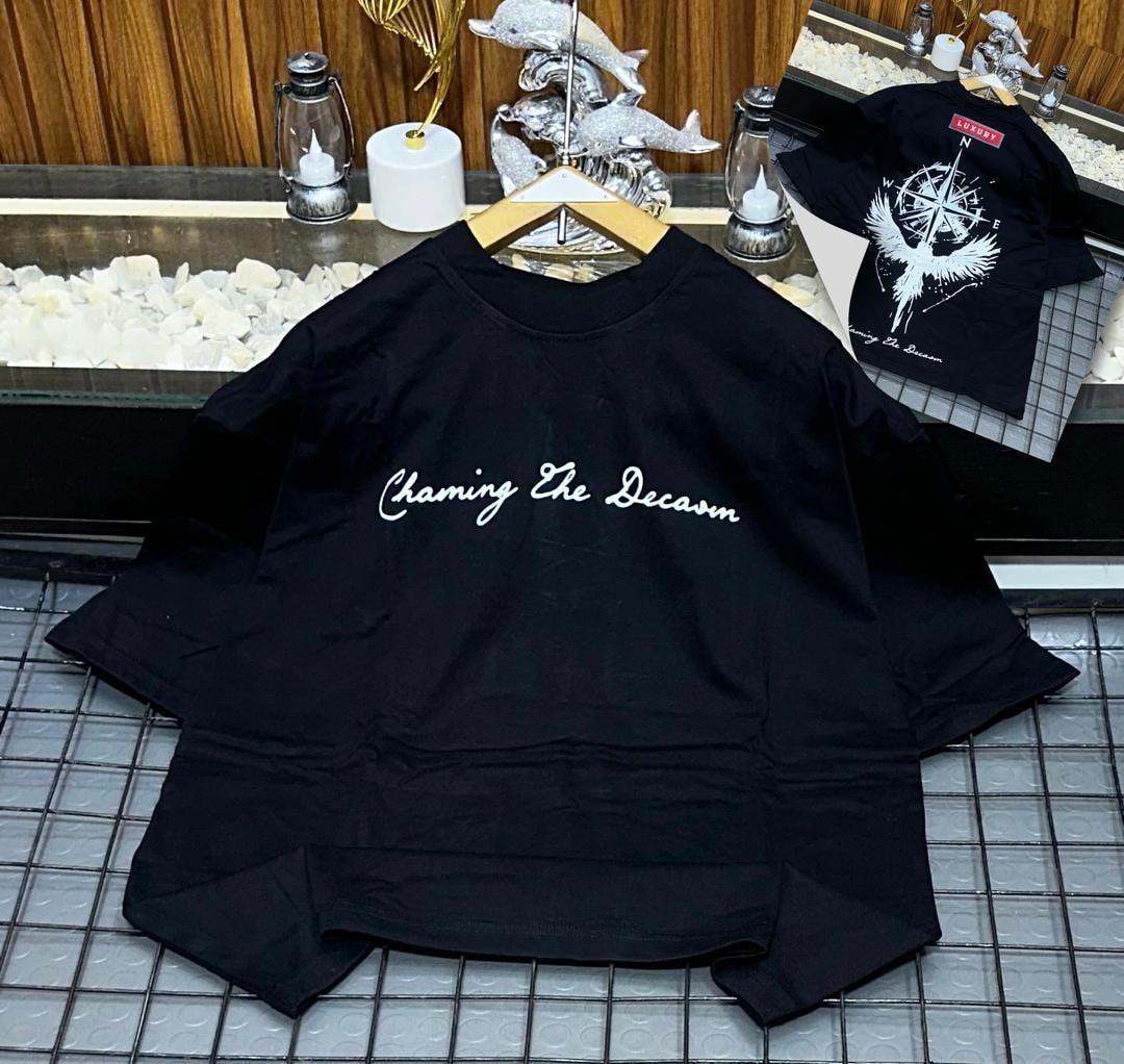 Black oversized t-shirt with white cursive 'Chaming The Decaom' print on front and inset bird compass back view.