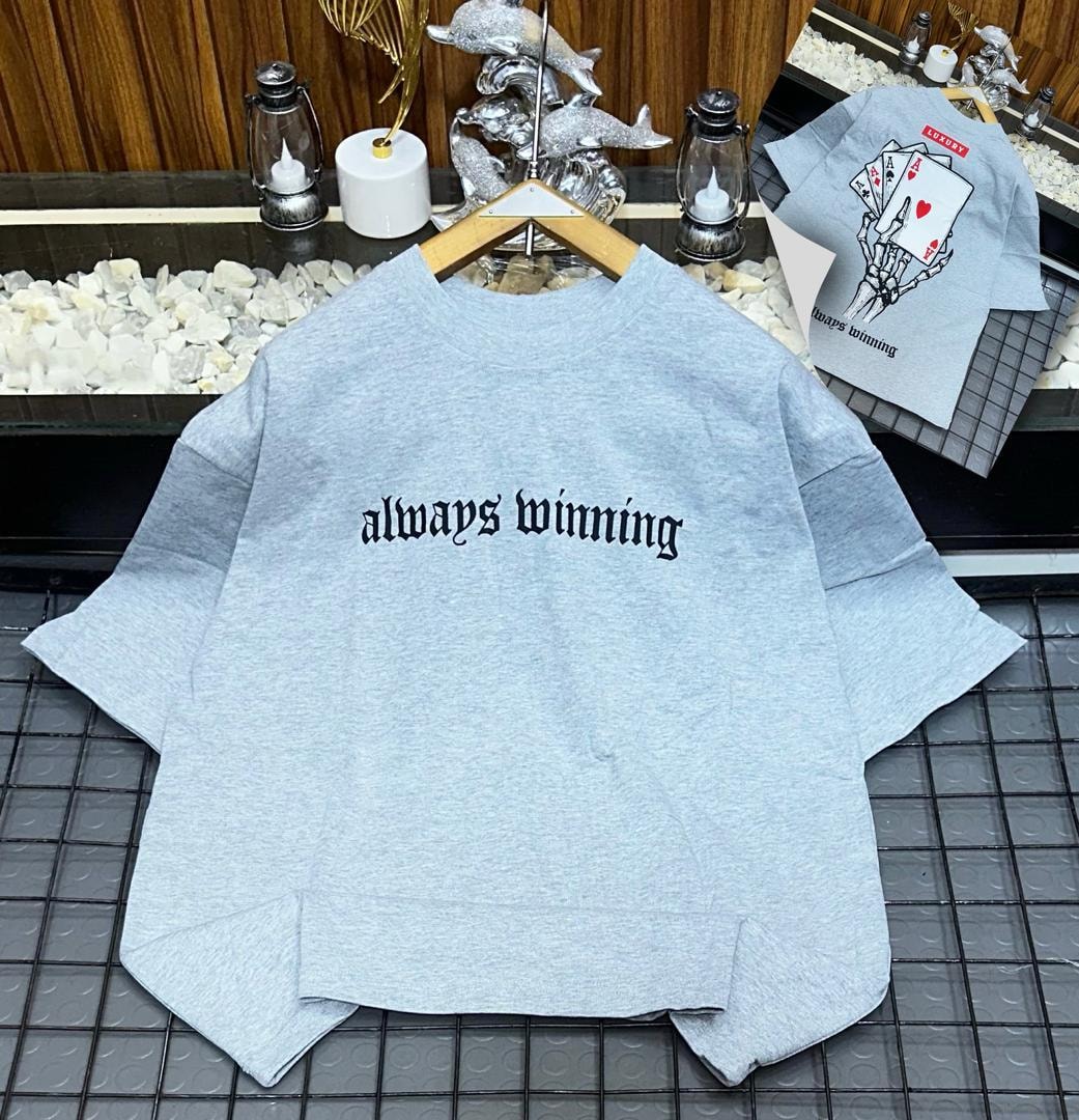 Light gray oversized t-shirt with black 'always winning' gothic text on front and skeleton card graphic on back.