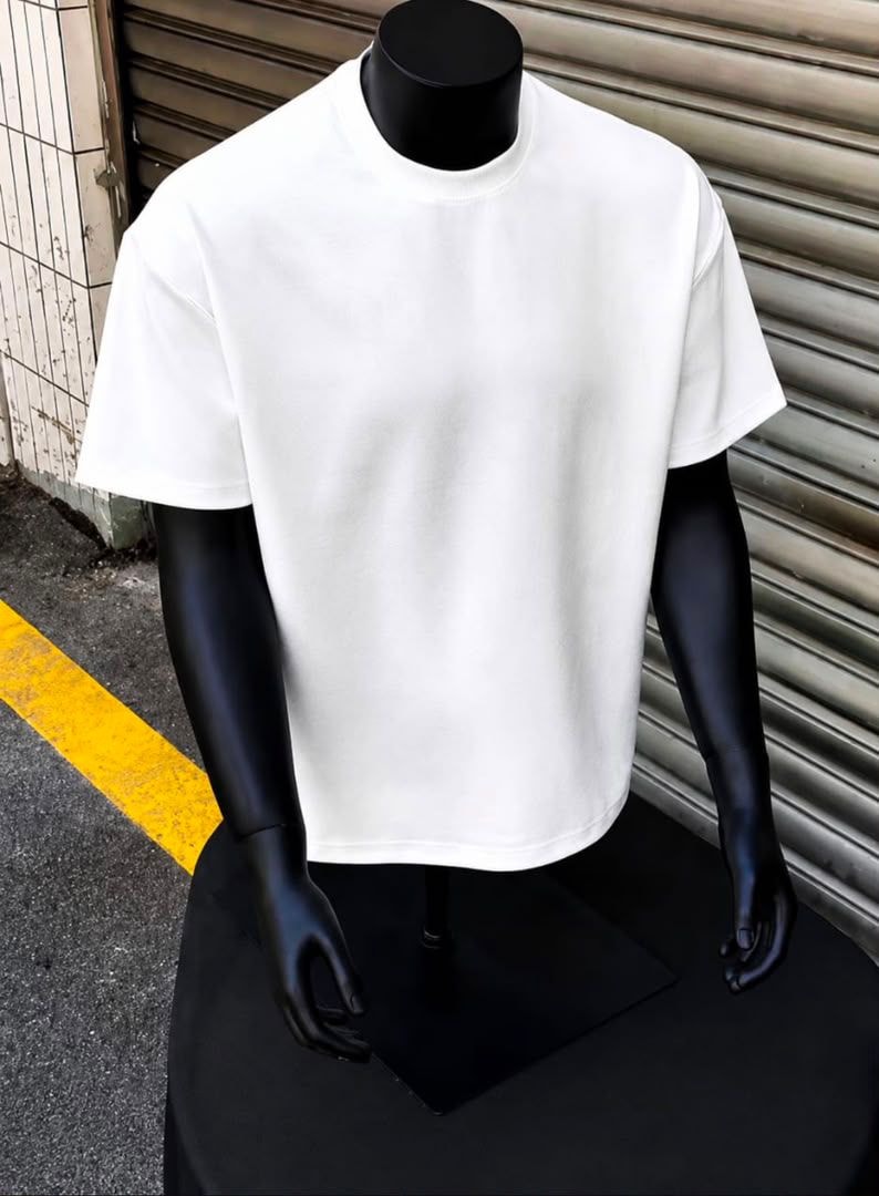 White plain oversized t-shirt displayed on black mannequin outdoors.