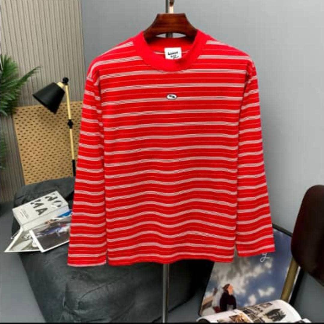 Red and white striped long sleeve top on stand in indoor setting with decor.