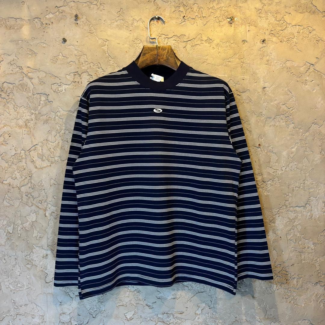 Navy blue and white horizontally striped long sleeve top on wooden hanger.