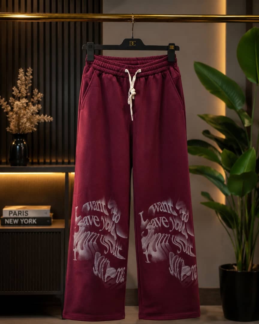 Burgundy joggers with white graphic text and heart designs on the legs.