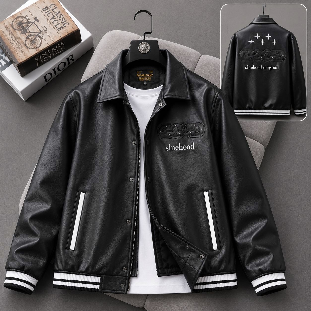 Black bomber jacket with sinehood embossed text on front and back, shown on hanger with inset rear view.