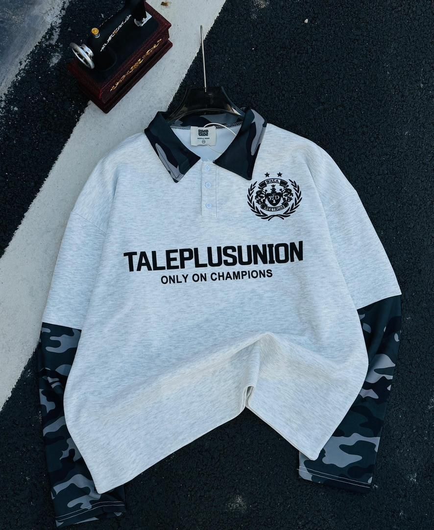 Light gray long sleeve polo with black camo collar and sleeves plus black chest graphic.