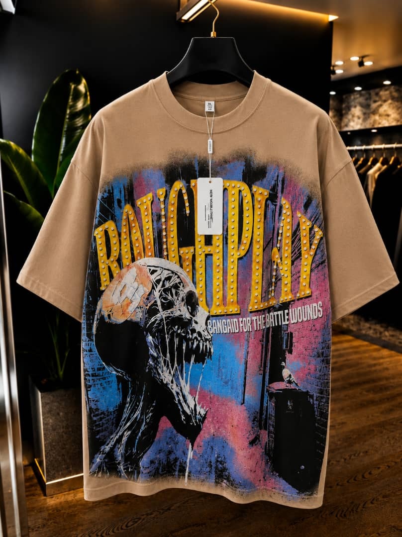 Beige oversized t-shirt with roughplay skull and marquee graphic print.
