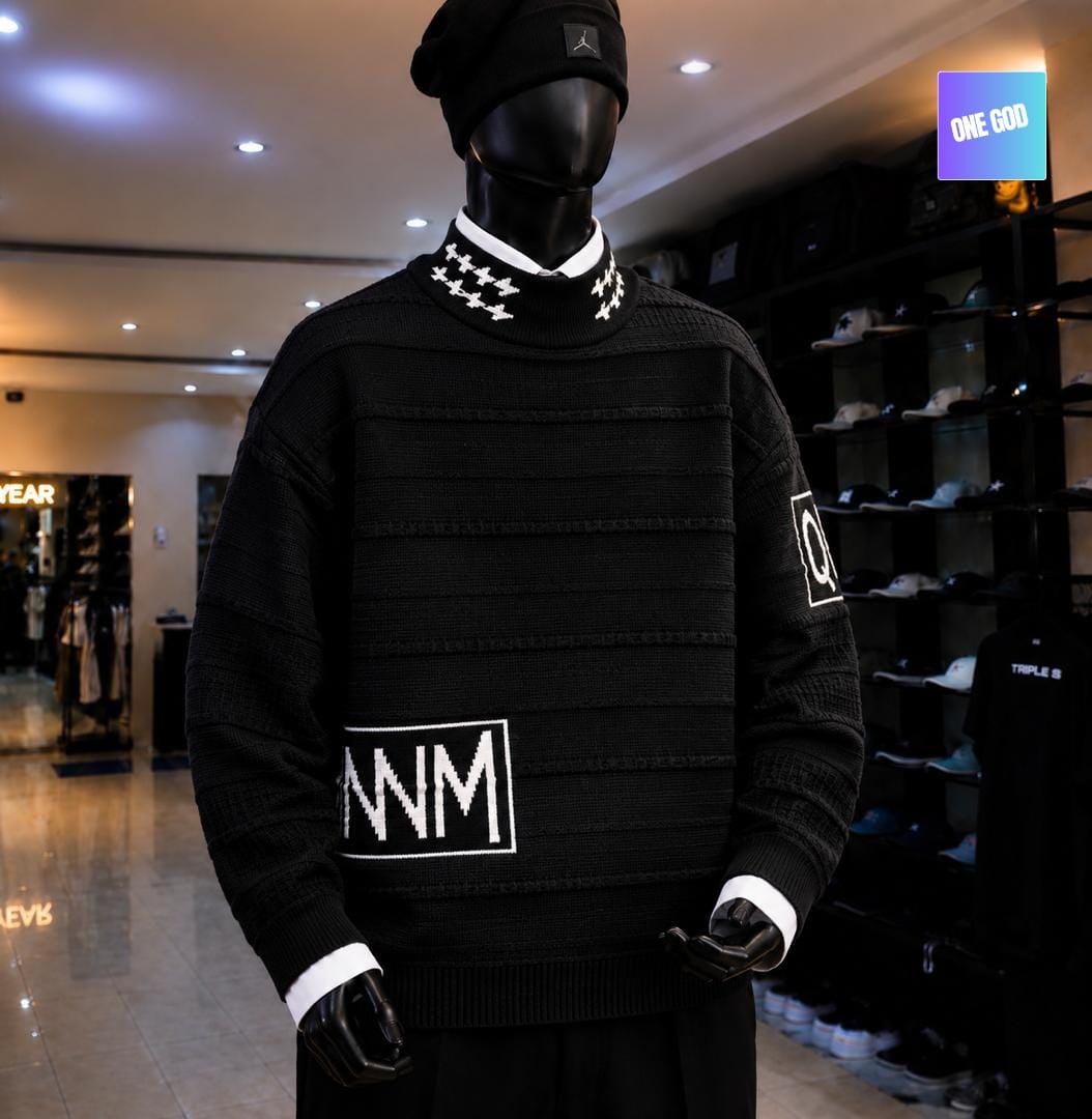 Black knit sweater with white NNM graphic, striped texture and patterned neck on mannequin.