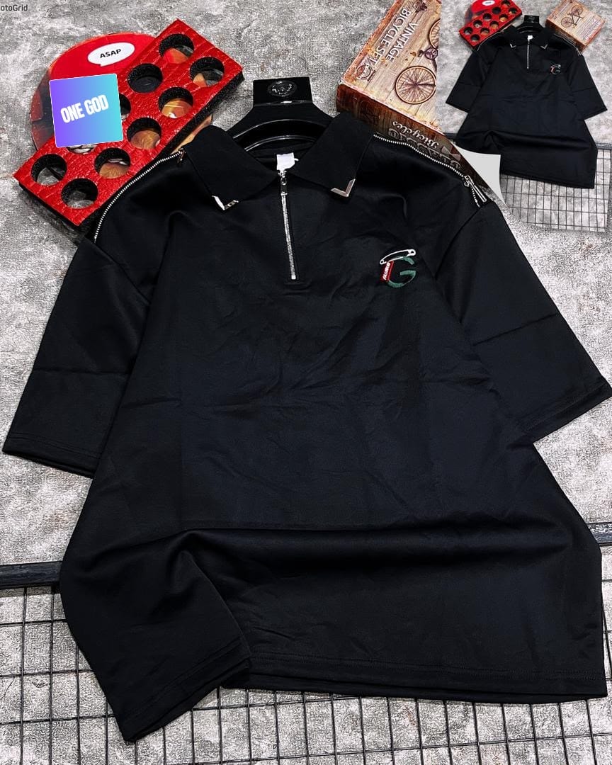 Black quarter-zip polo with shoulder zips and embroidered logo on grey background.