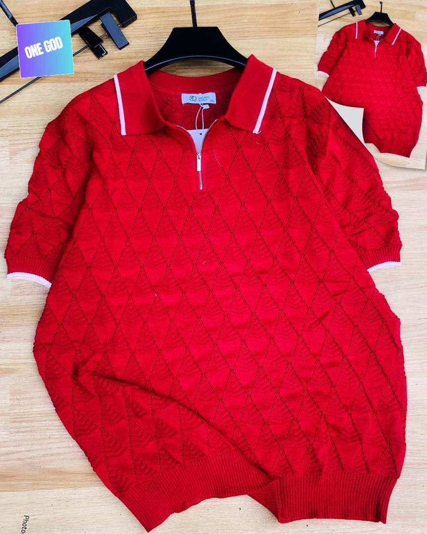 Red argyle knit quarter-zip polo shirt laid flat on wooden surface.