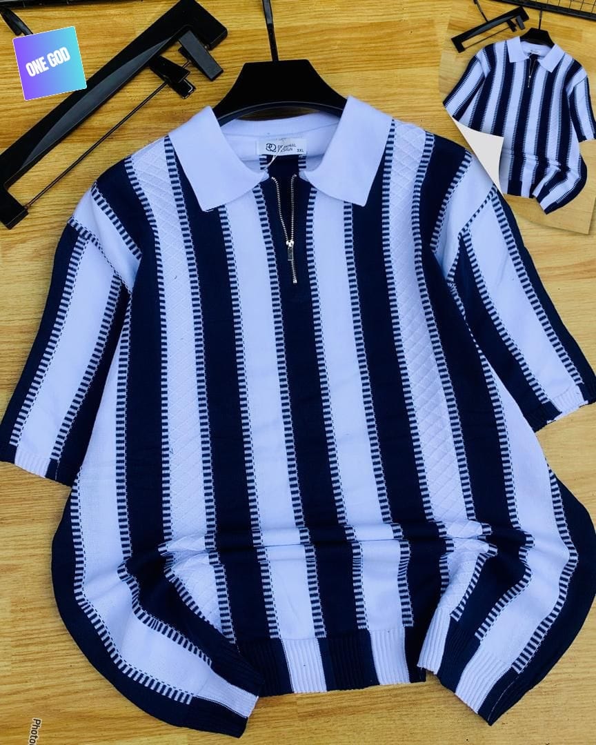 Navy and white vertically striped quarter-zip knit polo on hanger with wooden background.
