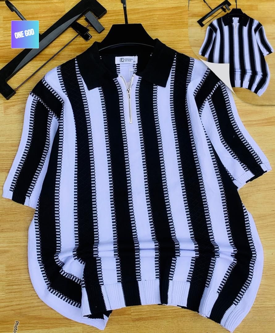 Black and white vertically striped quarter-zip knit polo on hanger with wooden background.