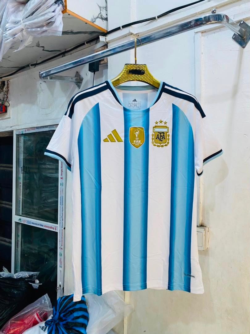 Light blue and white striped Argentina national team Adidas jersey hanging indoors.