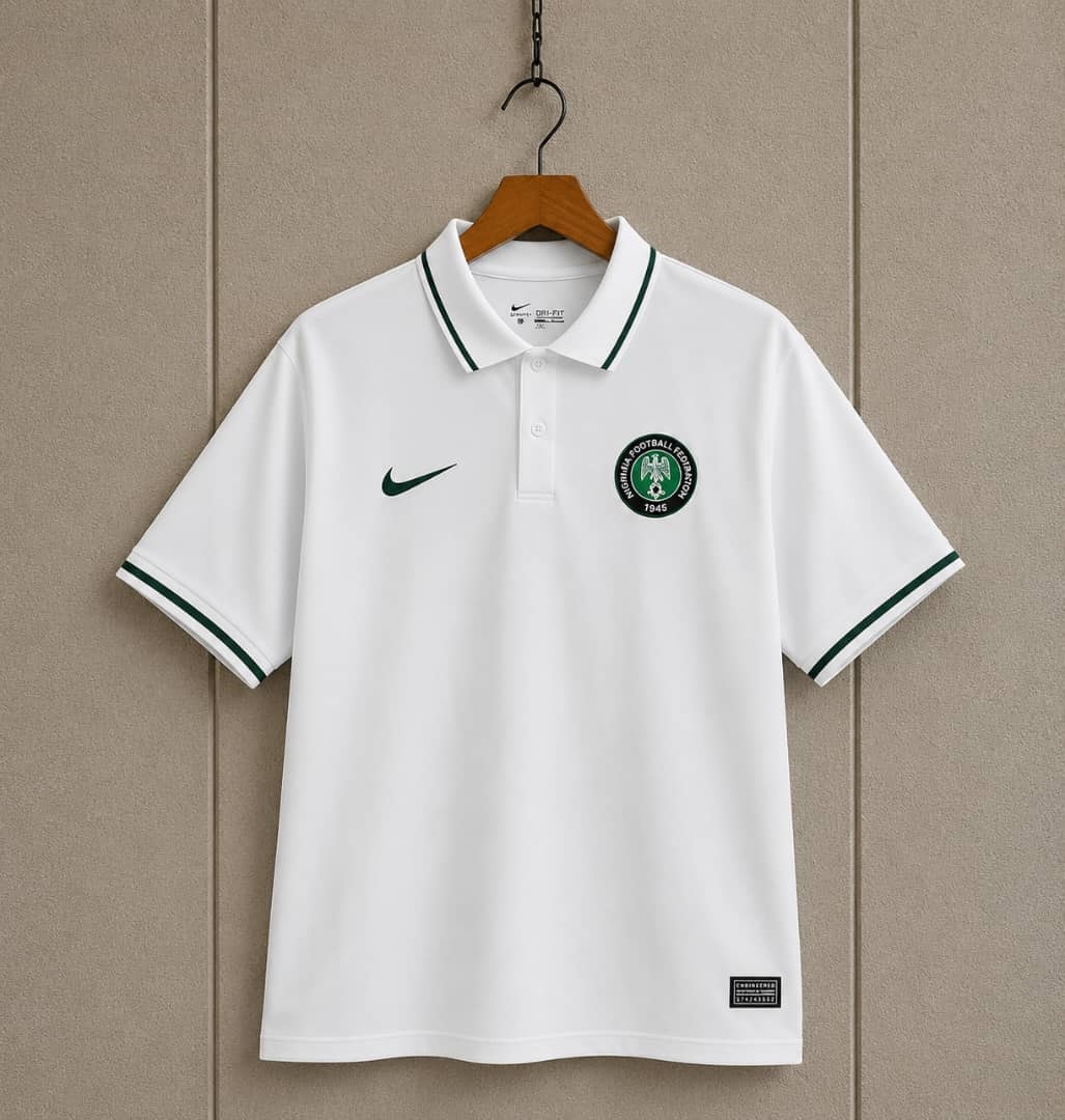 White Nigeria football federation Nike polo jersey hanging against a neutral wall.
