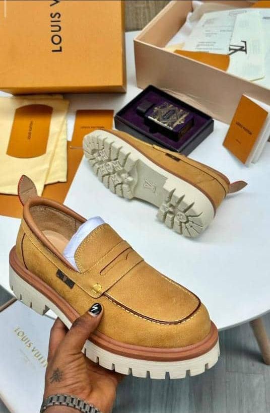Tan Louis Vuitton suede loafers with white chunky sole held with luxury LV packaging and boxes.