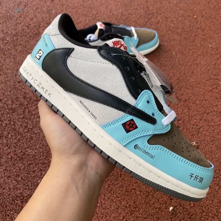 Multi-color Nike Jordan 1 style sneaker held in hand showing side profile with graphics and text.