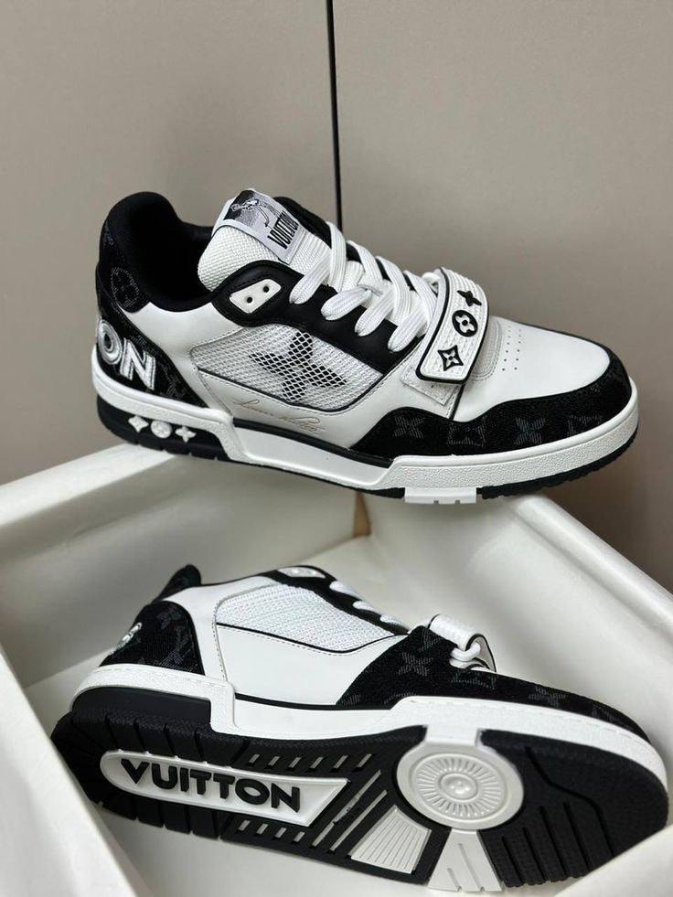 White and black Louis Vuitton style sneakers with monogram and logos shown in a white box.