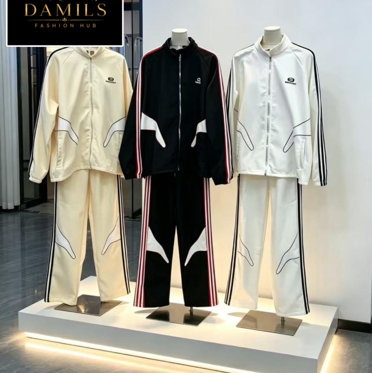 Three mannequins displaying cream, black and white Balenciaga tracksuits.