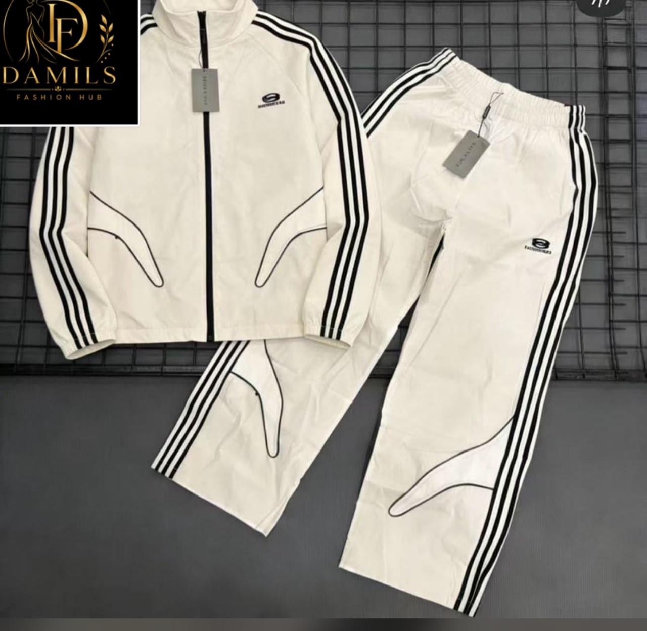 White Balenciaga tracksuit set laid flat on grid with tags.