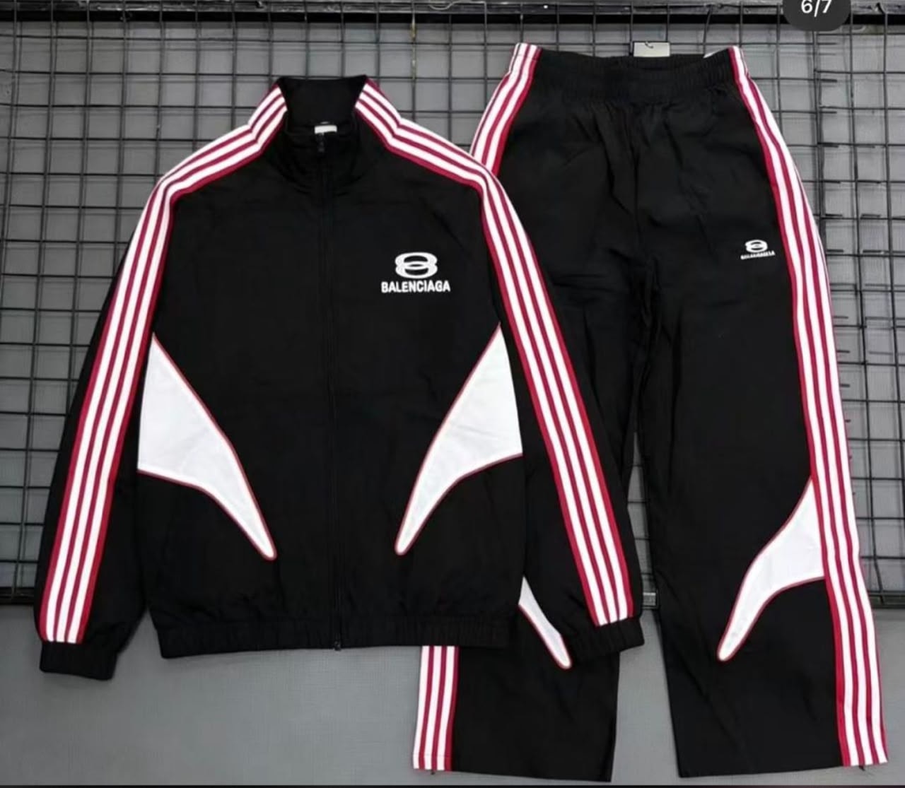 Black Balenciaga tracksuit set laid flat showing jacket and pants.