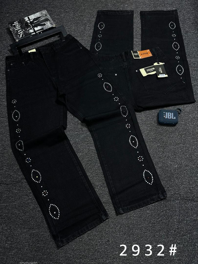 Black jeans with oval and circular rhinestone patterns on sides shown in flat lay with accessories.