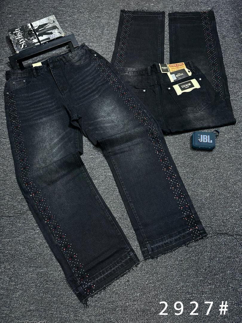 Black washed denim jeans with colorful rhinestone patterns on sides and back views on gray surface.