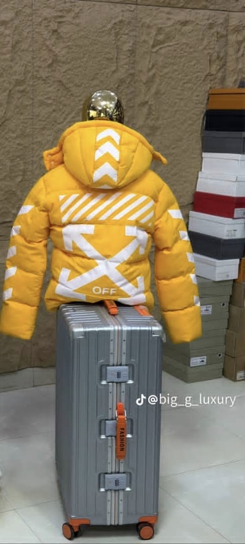 Back view of yellow puffer jacket displaying white chevrons, arrows and OFF text.
