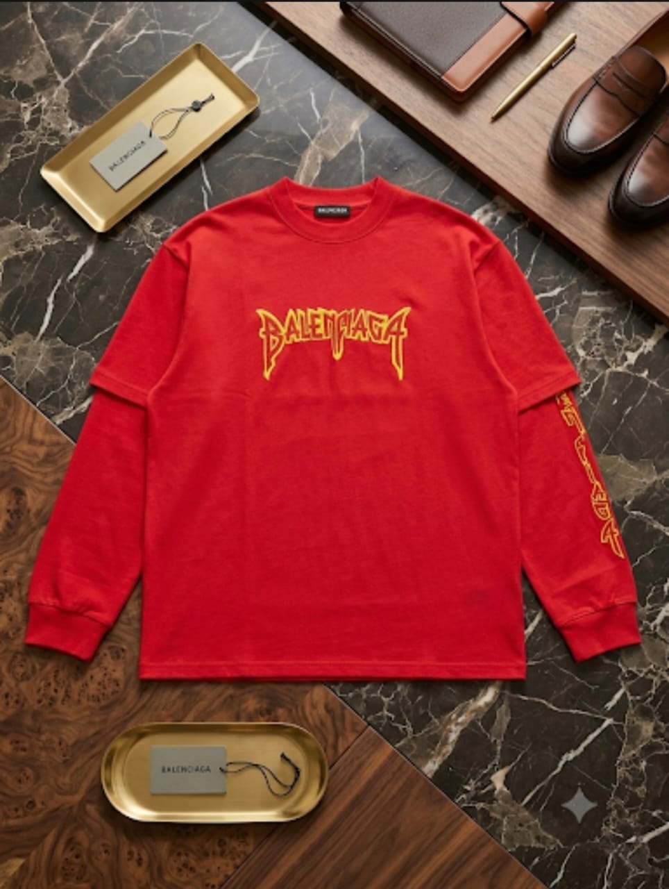 Red Balenciaga flame print sweatshirt styled on wood and marble with accessories.