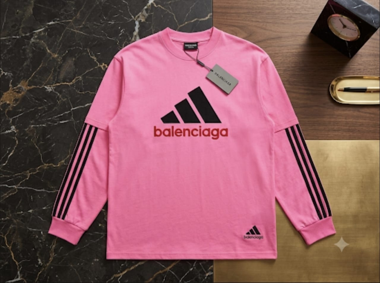 Pink Balenciaga Adidas sweatshirt flat lay on marble and wood surface.