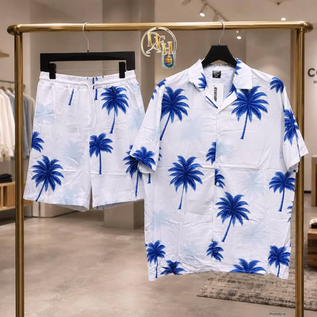 White short sleeve shirt and shorts set with blue palm tree prints shown on a gold clothing rack.