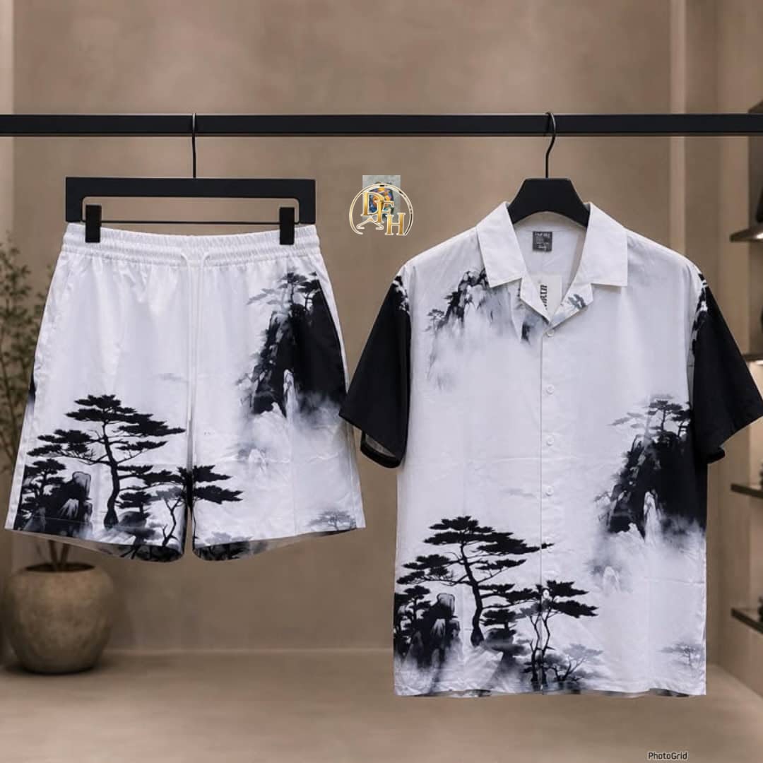 White short sleeve shirt and shorts set with black mountain and tree landscape print on a clothing rack.