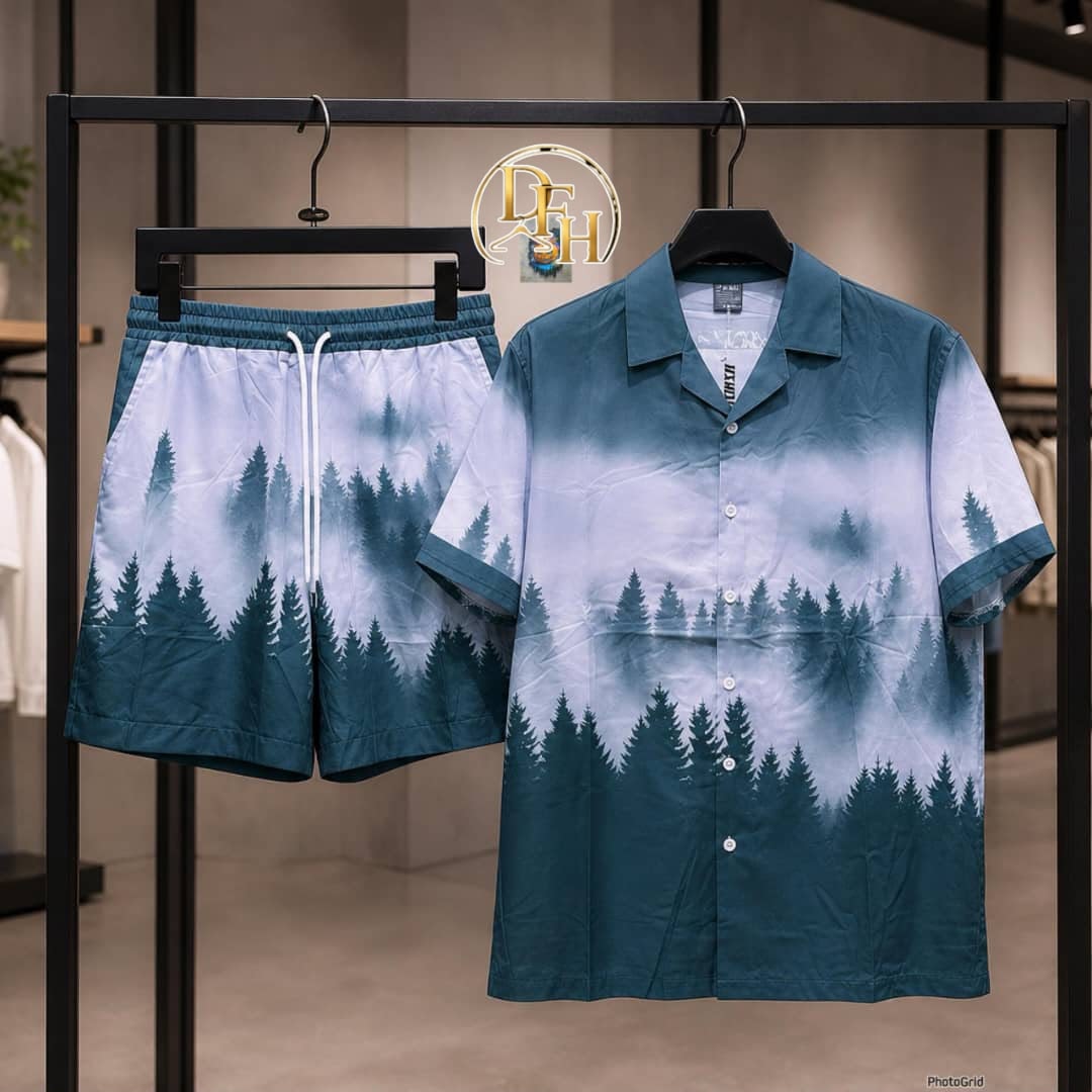 Teal short sleeve shirt and shorts set with forest tree silhouette print displayed on a clothing rack.