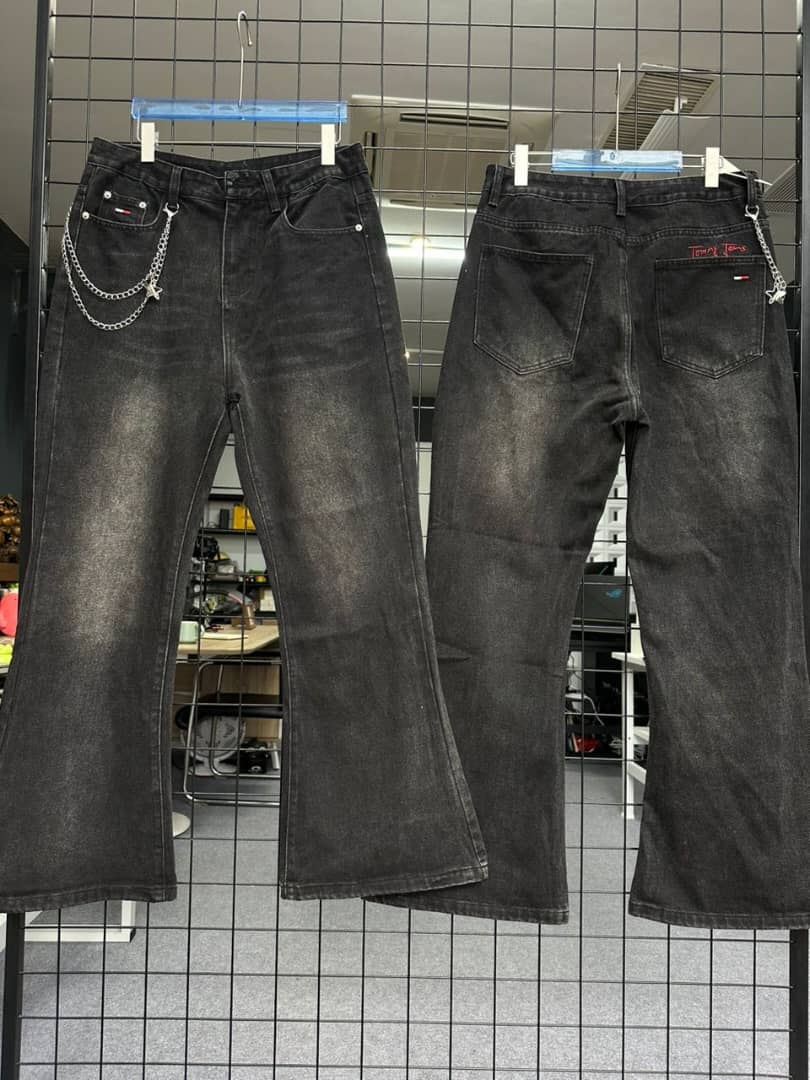 Black Tommy Hilfiger baggy jeans with chain accessory, front and back views on grid wall.