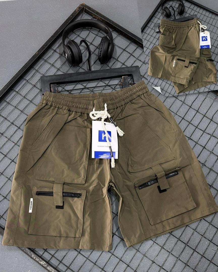 Olive tactical cargo shorts with utility pockets, buckles and branding tags.