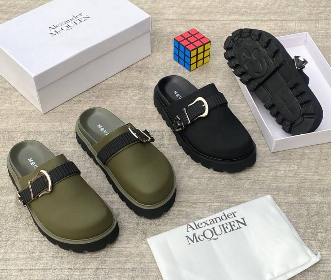 Olive and black platform mules with buckle straps displayed with Alexander McQueen box, Rubik's cube and dust bag.