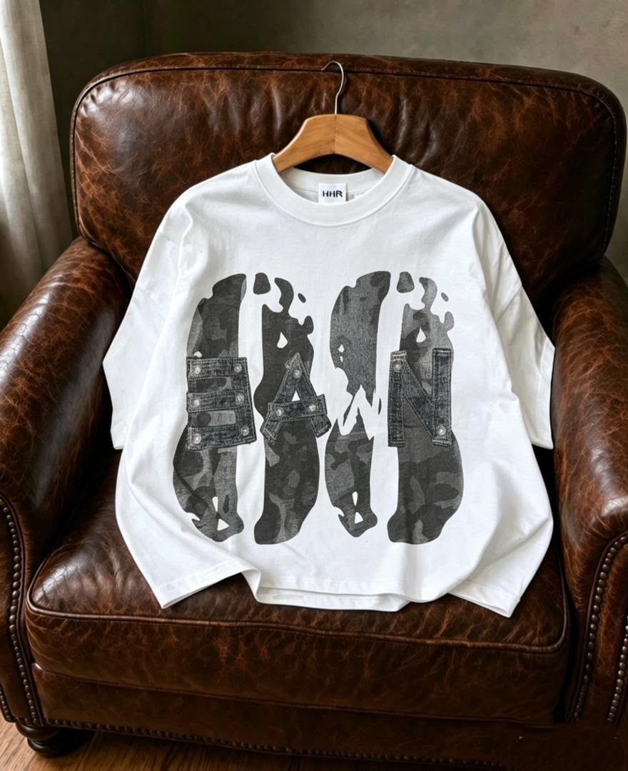 White Dawn graphic t-shirt with stylized lettering, displayed on chair.