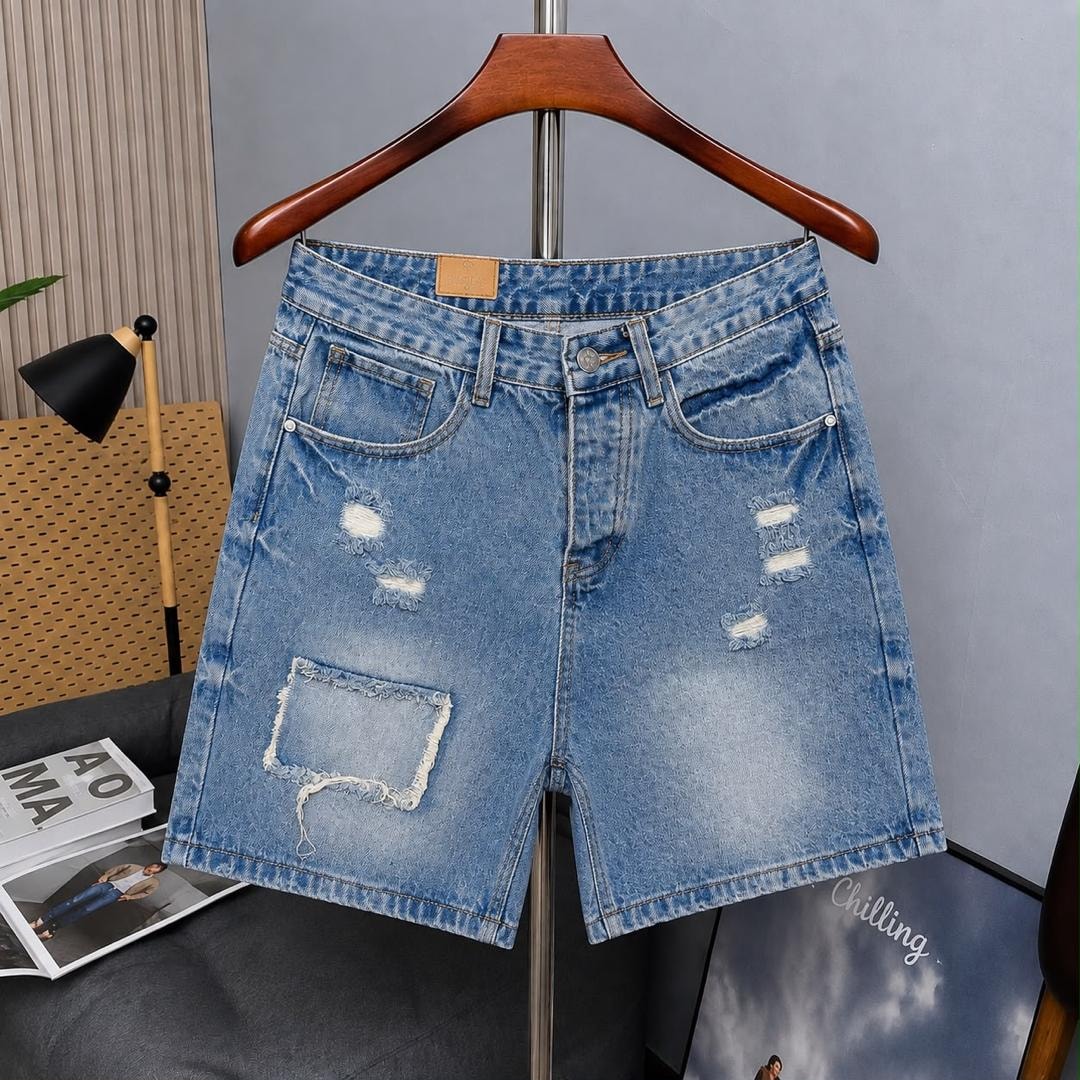 Light blue denim shorts with front patch pocket and distressing on hanger.