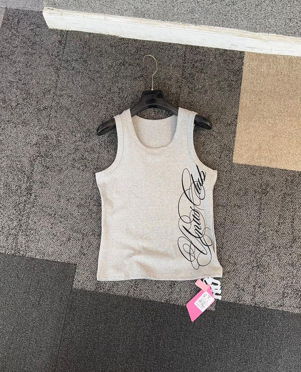 Grey armless tank top with black cursive script print on the side, hanging on a black hanger.