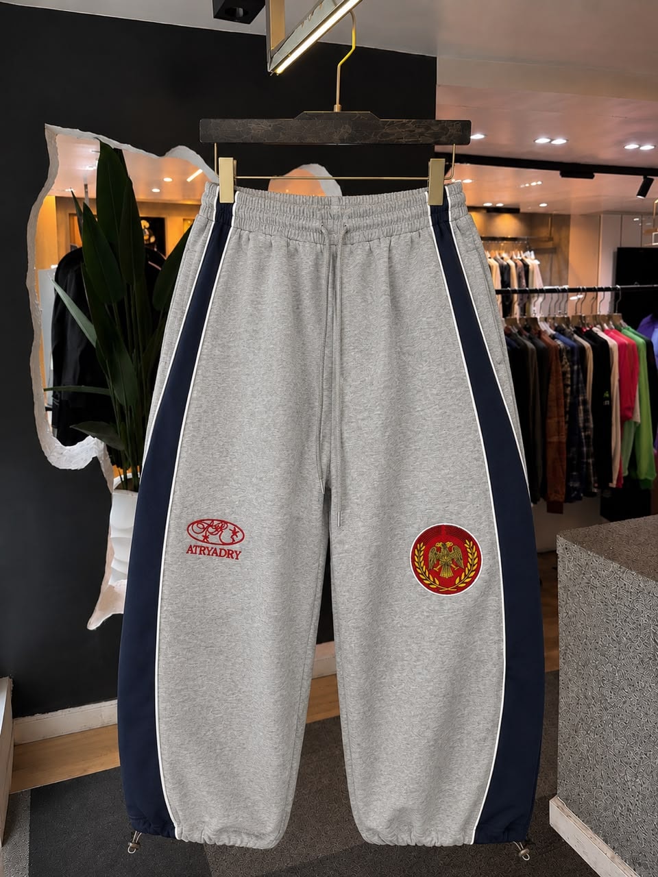 Grey Atryadry joggers with navy side stripes and embroidered logos on thighs.
