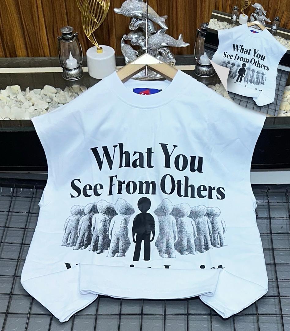 White oversized armless top with What You See From Others text and figure graphic.