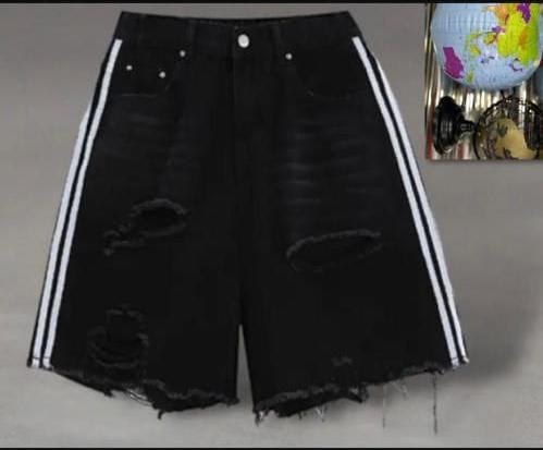 Front view of black ripped denim shorts with white side stripes against neutral background.