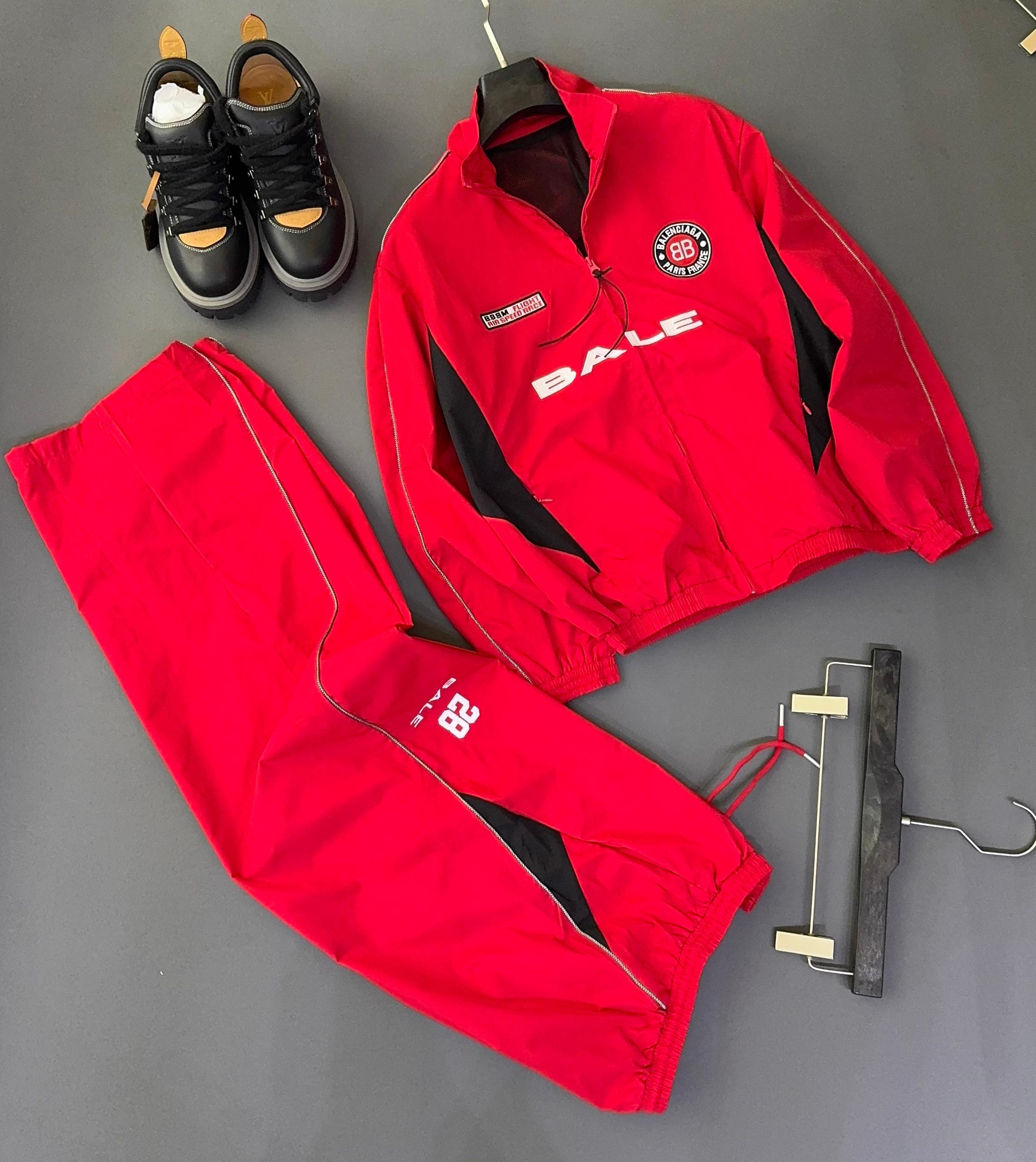 Red Bale two-piece tracksuit front view showing BALE text, circular logo, and black contrast panels with red pants.
